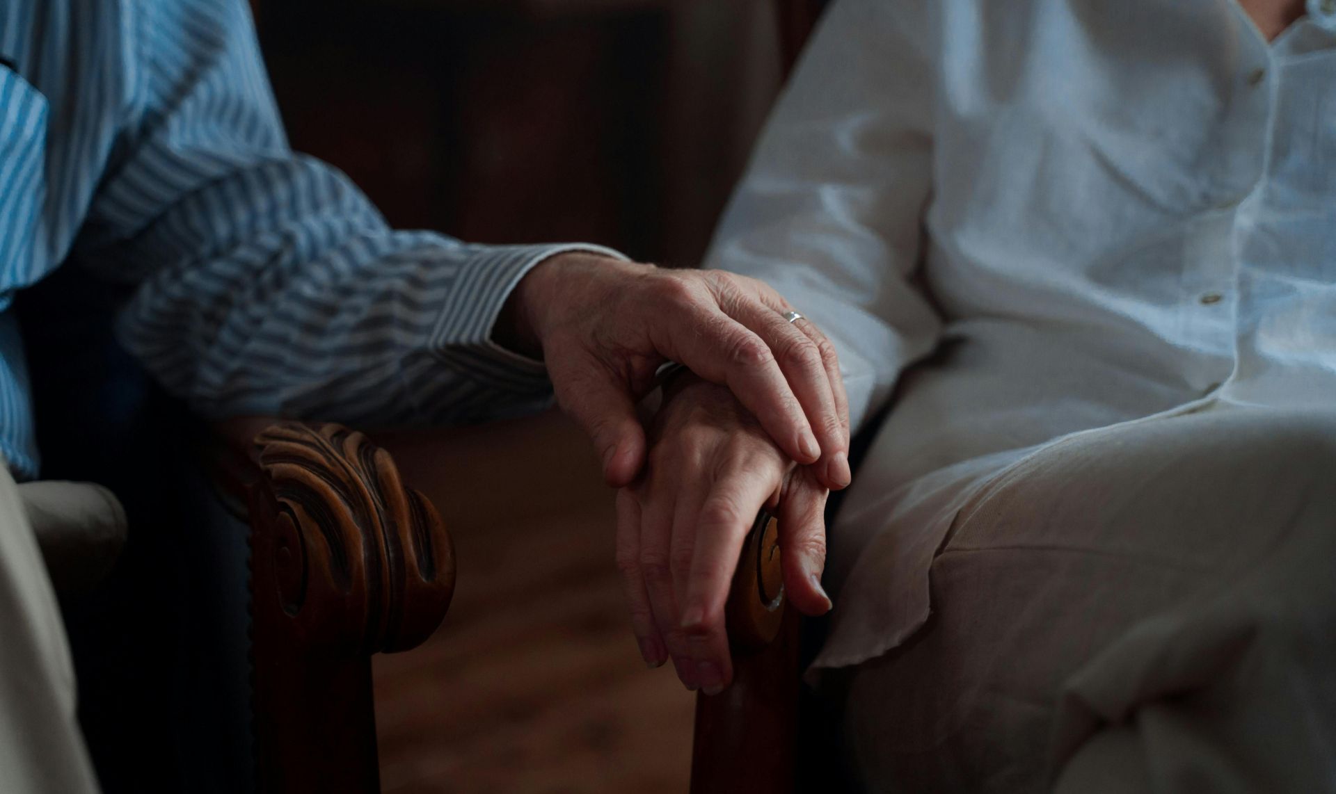 An intimate moment of an elderly couple holding hands, capturing love and companionship.